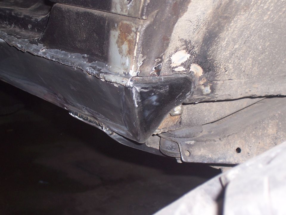 Vehicle undercarriage with visible rust and recent welding on the rocker panel