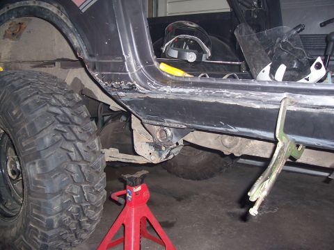 1988 Suzuki Samurai - Suzuki Samurai rocker panel rust repair in progress, with a large off-road tire visible.