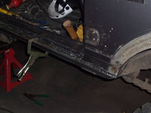 1988 Suzuki Samurai - Vehicle rocker panel undergoing repair work, held in place with clamps and welding.