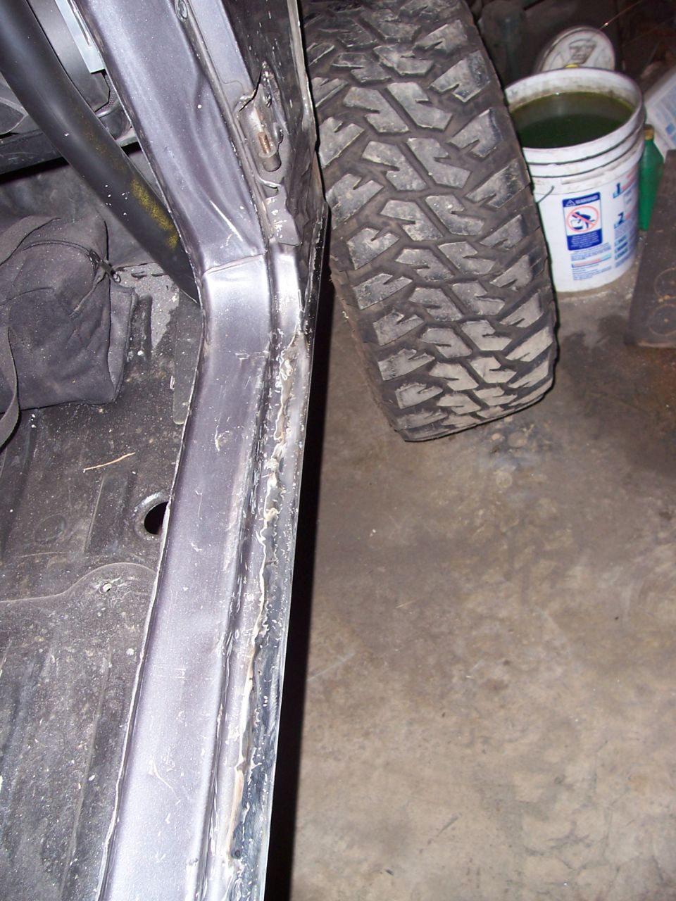 Off-road tire next to vehicle interior with roll cage