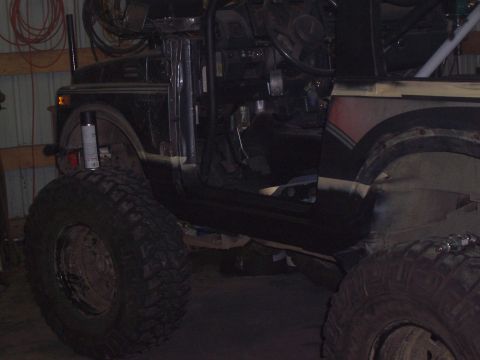 1988 Suzuki Samurai - This modified off-road vehicle shows its interior, large tires, and roll cage structure.