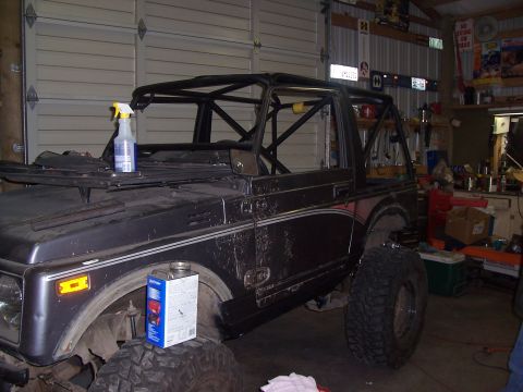 1988 Suzuki Samurai - A Suzuki Samurai is shown in a garage with a custom roll cage installed.
