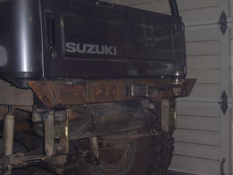 1988 Suzuki Samurai - Rear view of a black Suzuki Samurai showing its custom bumper and suspension components.