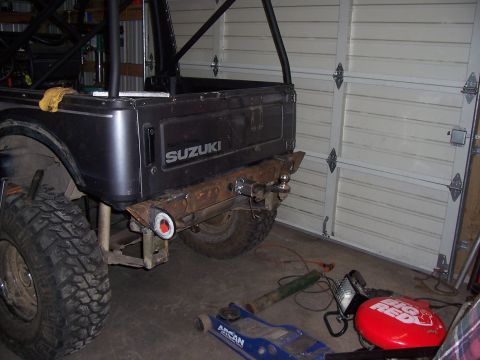 1988 Suzuki Samurai - Rear view of a Suzuki Samurai with a custom bumper and roll cage, parked in a garage.