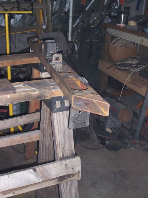 1988 Suzuki Samurai - A metal frame part rests on sawhorses in a cluttered workshop environment.
