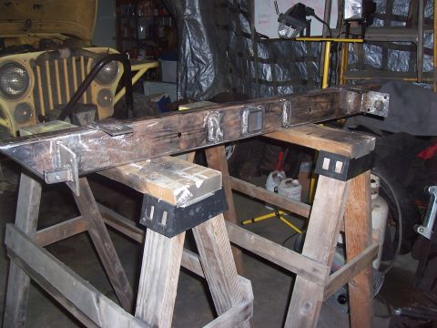 1988 Suzuki Samurai - A fabricated metal frame is supported by sawhorses in a workshop environment.