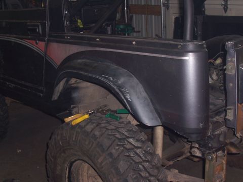 1988 Suzuki Samurai - Close-up view of a modified Suzuki Samurai's fender and tire, suggesting off-road customization.