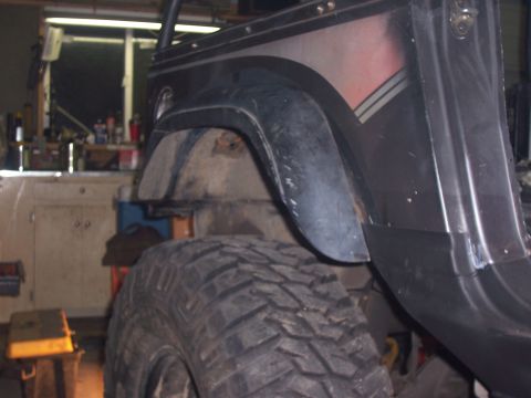 1988 Suzuki Samurai - Close-up of a vehicle's rear fender and tire, showing off-road modifications.