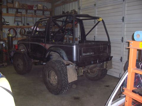 1988 Suzuki Samurai - This modified Suzuki Samurai features a prominent roll cage and off-road tires, suggesting it's built for terrain.