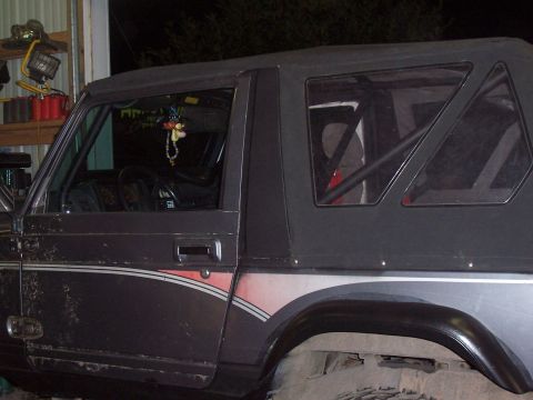 1988 Suzuki Samurai - This vehicle appears to be a modified SUV, possibly undergoing some work in a garage or workshop.