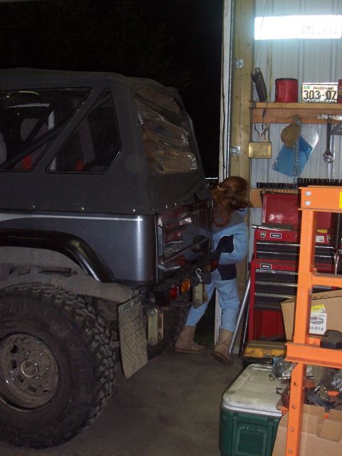 1988 Suzuki Samurai - A 1988 Suzuki Samurai is parked in a garage, showing its rear end and large off-road tires.