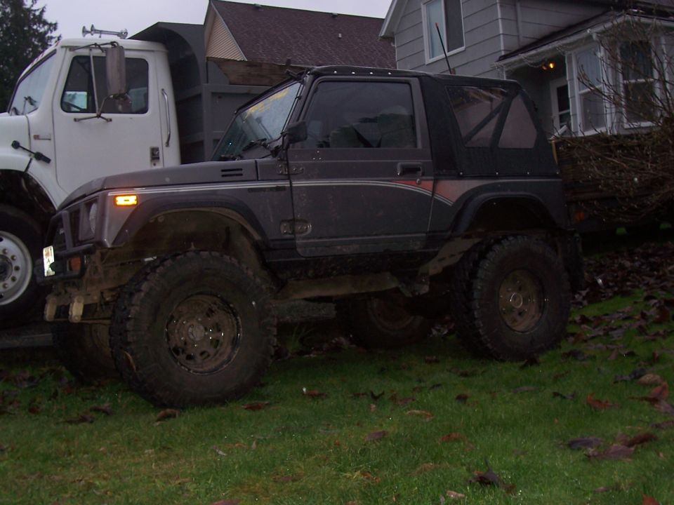 Side view of a dark gray off-road vehicle with a soft top and large tires