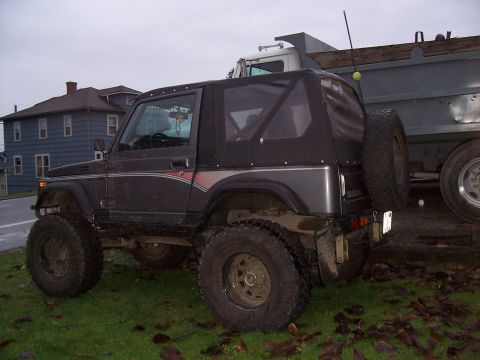 1988 Suzuki Samurai - Suzuki Samurai parked on grass, with a dump truck behind it.