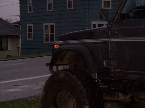 1988 Suzuki Samurai - A Suzuki Samurai is parked on a street in front of a blue house.