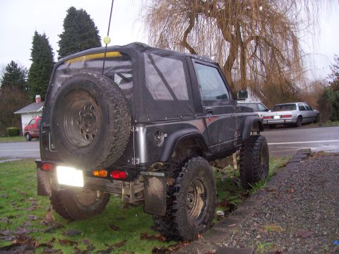 1988 Suzuki Samurai - Rear view of a modified 1988 Suzuki Samurai with a soft top and off-road tires.