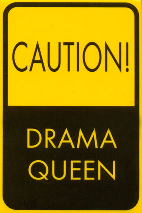 1986 Pontiac Fiero - A yellow and black sign reads "CAUTION!" above "DRAMA QUEEN", with a Supermotors.net logo at the bottom.