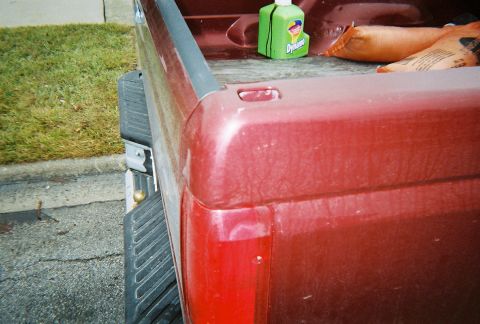 1996 Ford F-150 - Rear view of a 1996 Ford F-150 pickup truck bed with a step bumper and taillight visible.
