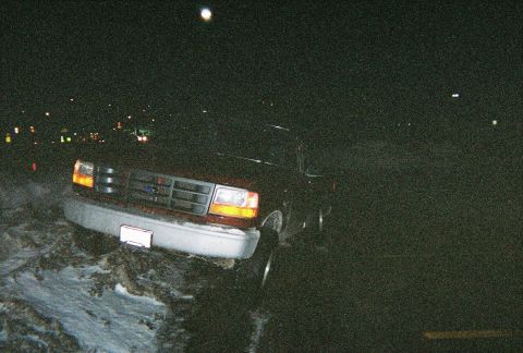 1996 Ford F-150 - A 1996 Ford F-150 is seen from a 3/4 front view at night, with its headlights illuminated.