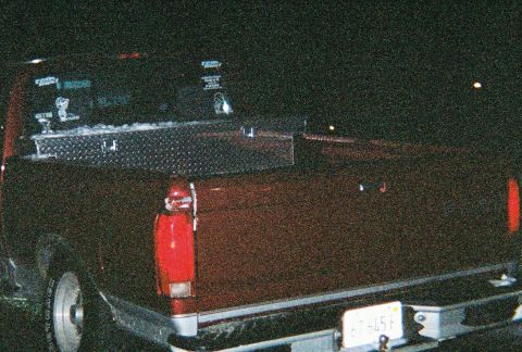 1996 Ford F-150 - A red pickup truck is viewed from the rear, equipped with a diamond plate tool box.