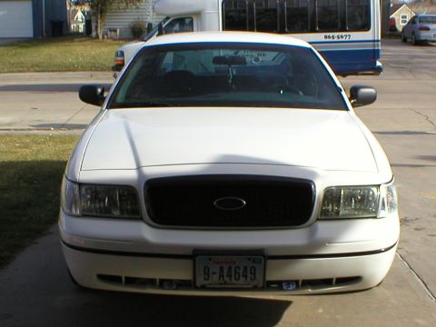 2000 Ford Crown Victoria - Front view of a white 2000 Ford Crown Victoria, a black grille and a license plate.