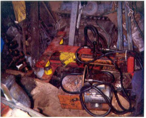 1989 Ford Bronco - A collection of engine parts and hydraulic equipment is visible in this workshop scene.