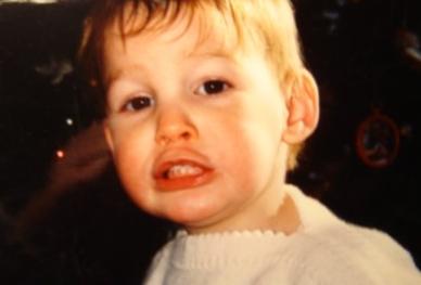 1999 Ford Taurus - A young child with blonde hair and wide eyes appears upset in this close-up photograph.