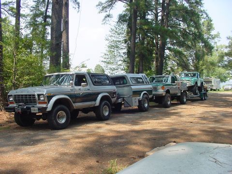 1978 Ford Bronco - A convoy of trucks including a 1978 Ford Bronco, a flatbed truck, and a Jeep on a trailer.