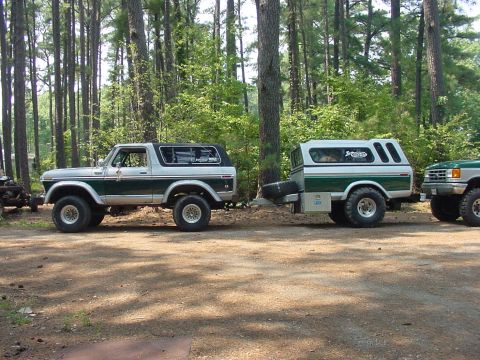 1978 Ford Bronco - A classic 1978 Ford Bronco is shown parked next to a custom trailer, with a portion of another vehicle visible in the background.