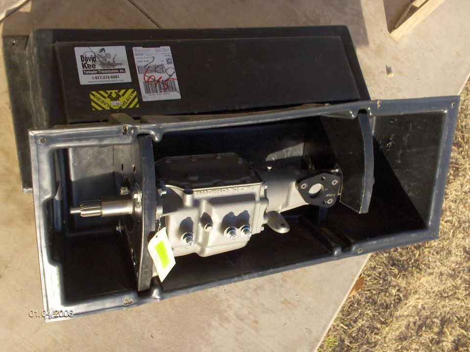 You can see how the toploader is secured inside the crate. Those two black collars are removable.  On the front collar there are two big bolts going through it and the tranny. The collars are bolted to the crate.