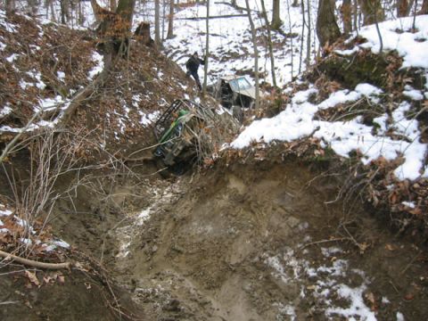 1992 Ford Bronco - Off-road vehicles struggle to navigate a steep, muddy ravine during winter conditions.