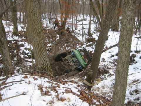 1992 Ford Bronco - An off-road vehicle is winched to a tree after getting stuck in a snowy ditch.
