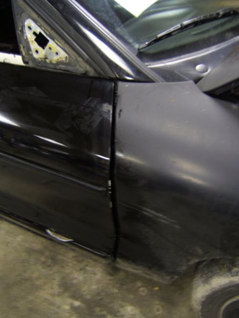 1993 Ford Probe - The seam between the car door and fender is visible, indicating bodywork or a door swap is in progress.
