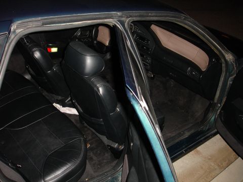 1993 Ford Taurus - The interior of a 1993 Ford Taurus shows black leather seats and a dark dashboard.