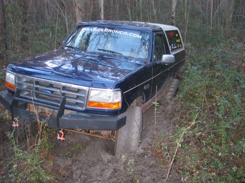 1995 Ford Bronco - Ford Bronco stuck in mud, with "FULLSIZEBRONCO.COM" sticker on windshield.