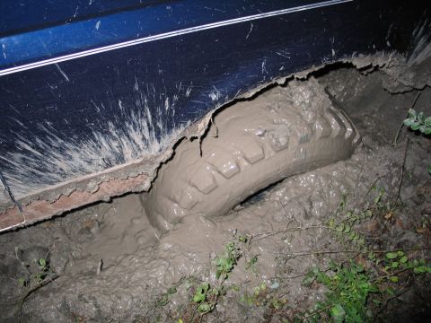 1995 Ford Bronco - This 1995 Ford Bronco is deeply mired in mud, with the tire almost completely submerged.