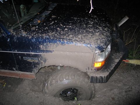 1995 Ford Bronco - This vehicle is deeply mired in mud, with the front tire almost completely covered.