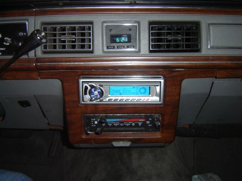 1988 Ford Crown Victoria LTD - Interior view of a car's dashboard an aftermarket stereo and digital clock.