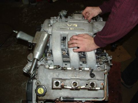1996 Ford Probe - A V6 24-valve Mazda engine is being worked on, with spark plugs exposed.