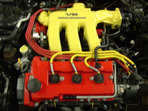 1996 Ford Probe - Close-up of a V6 engine, a bright yellow intake manifold and red valve covers with yellow spark plug wires.