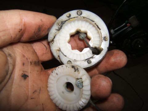1993 Ford Probe - A close-up shows a damaged plastic gear and cable, part of a vehicle's window operating system.