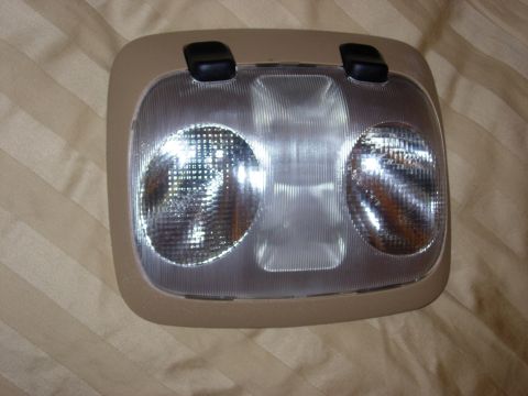 1998 Ford Crown Victoria - Interior dome light assembly with two bulbs and black buttons, likely for a vehicle.