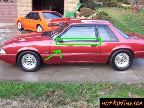 1986 Ford Bronco - A red coupe is parked in front of an orange coupe, with a garage in the background.