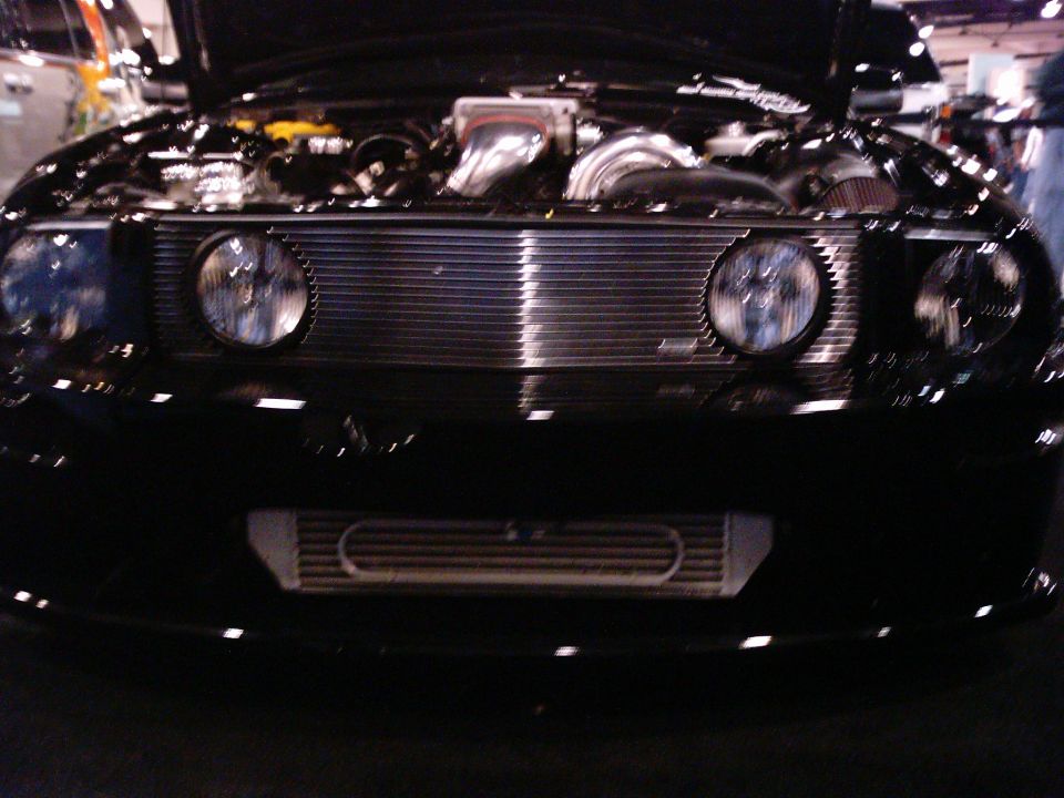 black car with hood open showing engine, chrome grille, and intercooler