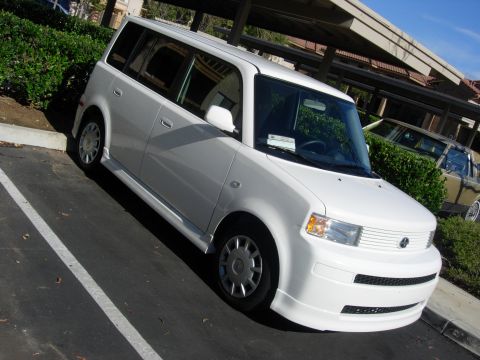 2006 Scion xB - A white 2006 Scion xB is parked in a lot, showing its distinctive boxy shape from a 3/4 front angle.