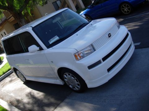 2006 Scion xB - A white Scion xB is parked on a street with a blue car in the background.