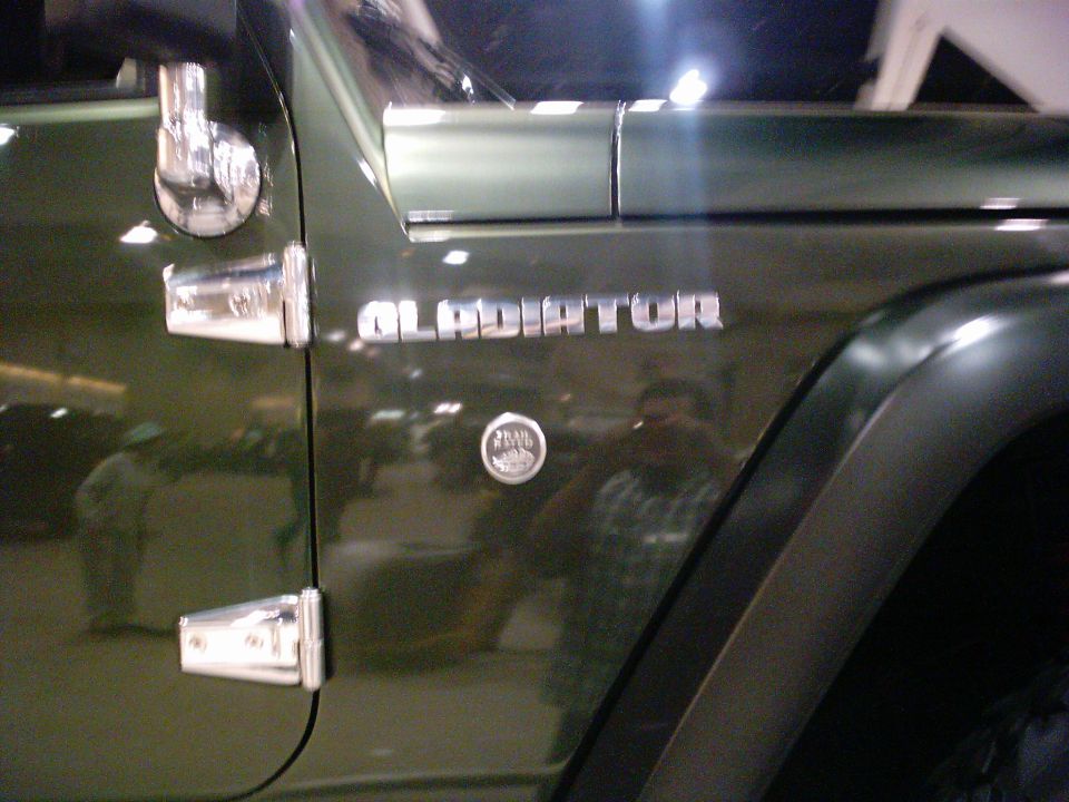 Green Jeep Gladiator fender badge on a dark green vehicle