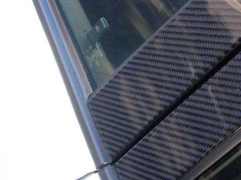 2006 Scion xB - Close-up of carbon fiber trim on a car's window frame, with 'TOYOTA' visible on the glass.