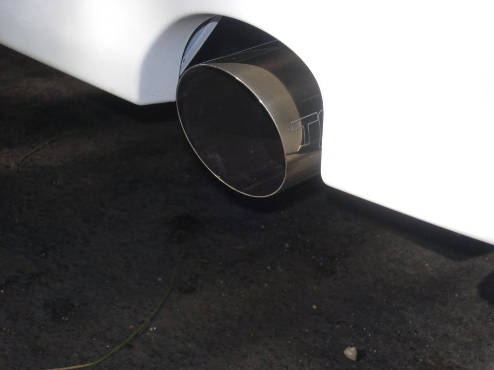 close-up of a car's exhaust pipe with a 'TT' logo etched on it