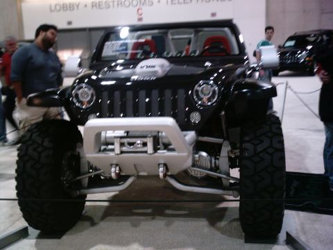 1986 Ford Bronco - A modified Jeep Wrangler is displayed indoors with a winch mounted on the front bumper.