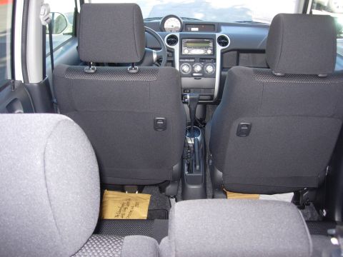 2006 Scion xB - The interior of a 2006 Scion xB, viewed from the back seat, reveals the dashboard, center console, and front seats.